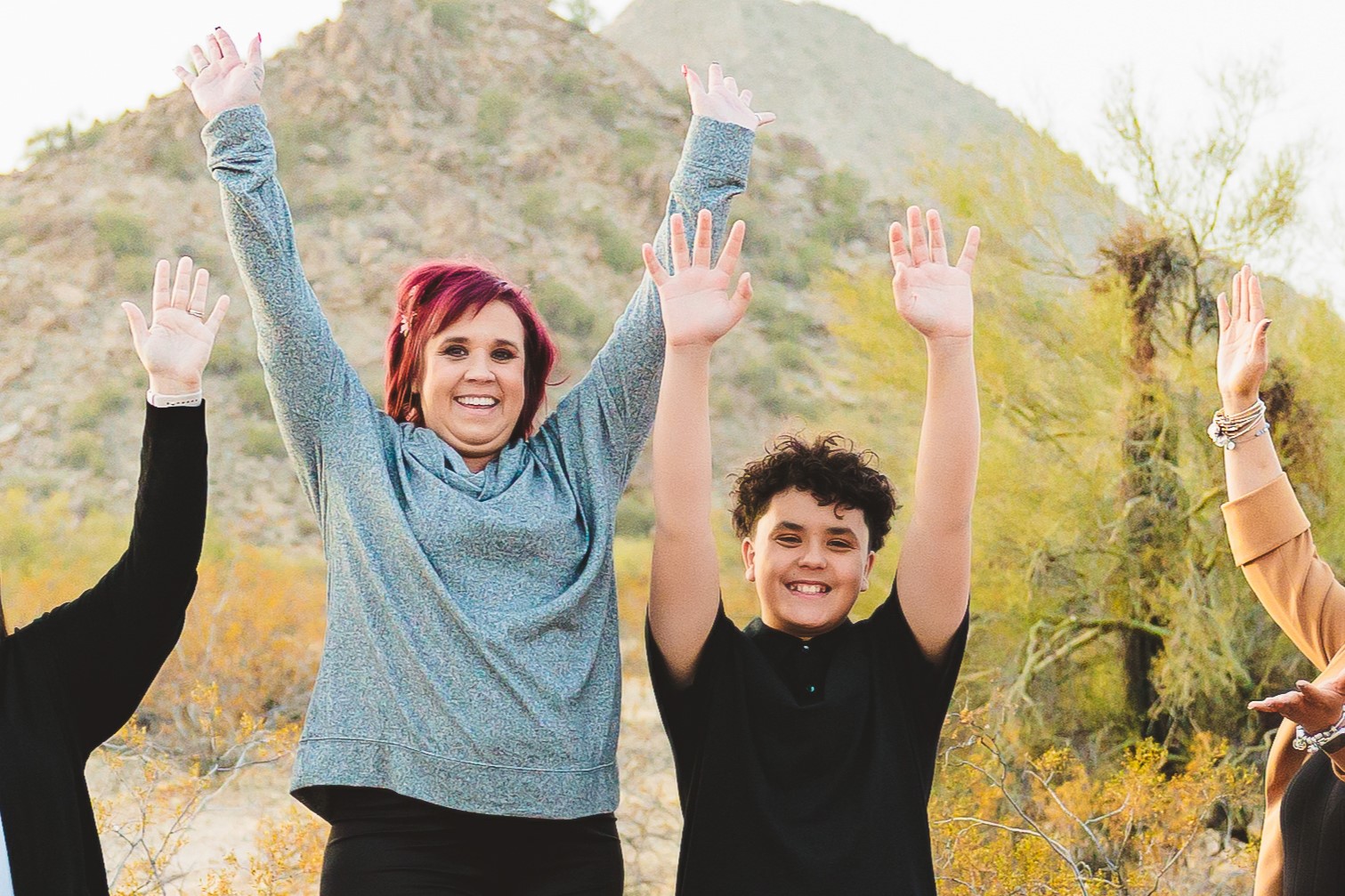 Dusty and her son smiling with supporters throwing their hands in the air.