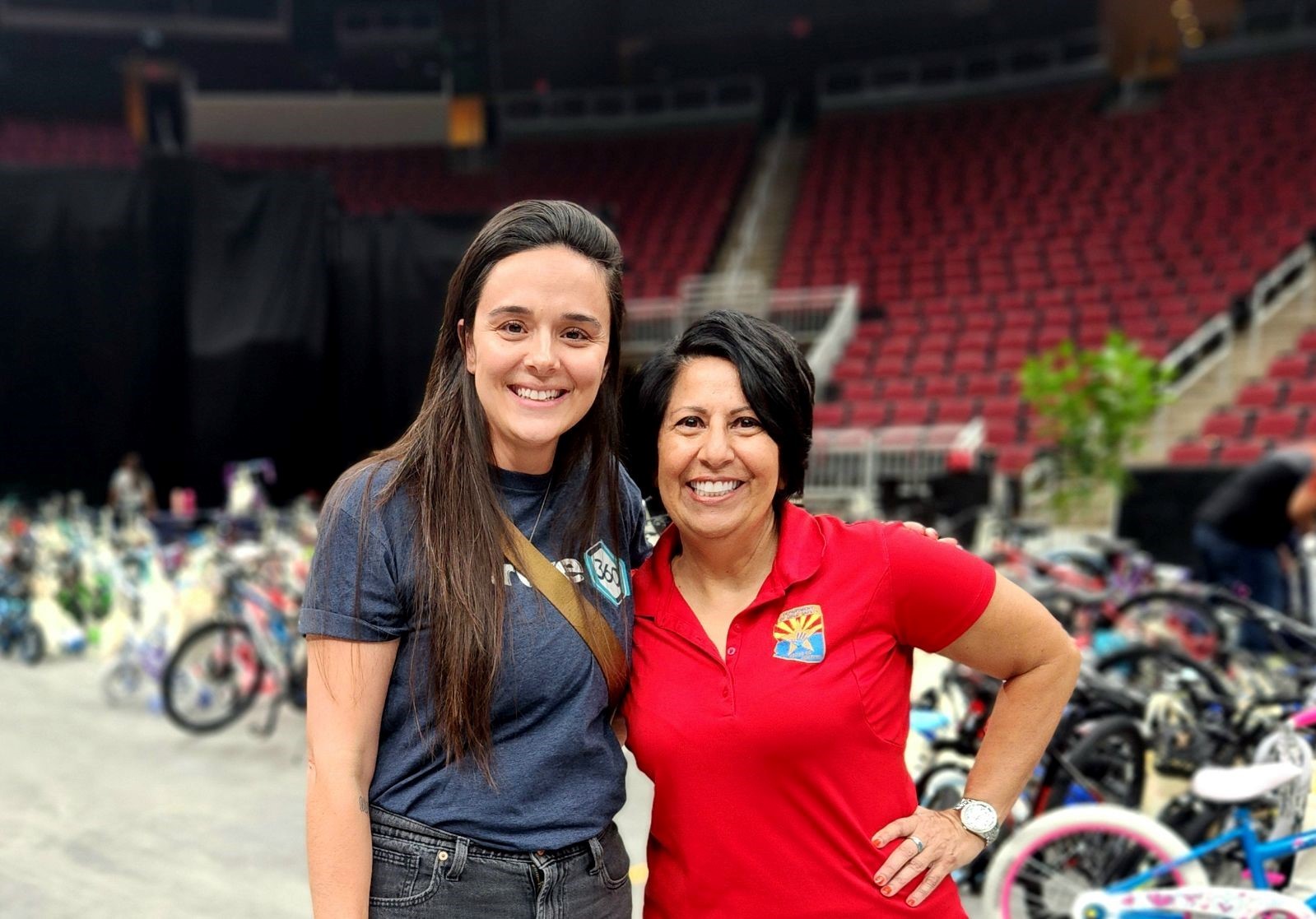 giving tree 2024 bike build event with two women volunteers smiling and bikes in the background