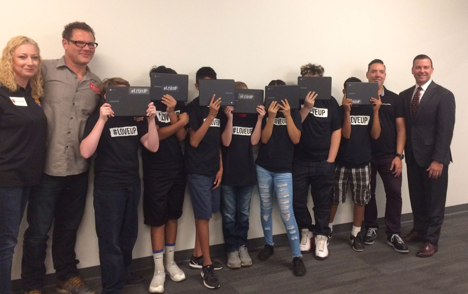 Pictured from left: DCS Deputy Director Shalom Jacobs; #LoveUp Foundation founder, Johnjay Van Es; foster youth posing with their new laptops; #LoveUp Foundation co-founder, Rich Berra; and DCS Director Greg McKay.